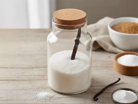 Skleněná dóza s cukrem a vanilkovým luskem uvnitř pro domácí výrobu vanilkového cukru.