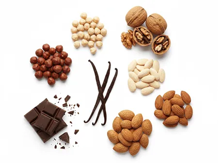 Různé druhy ořechů, vanilka a čokoláda jako ingredience pro chuťový profil pařížských rohlíčků.