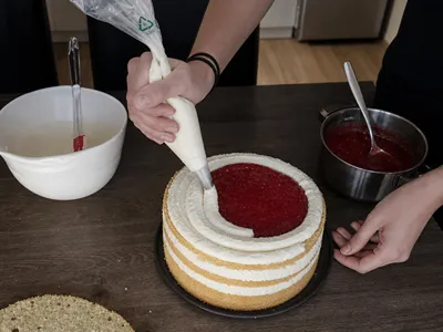 Nanášení mascarpone krému na dort.