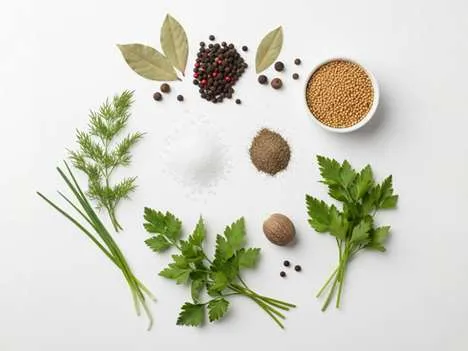 Koření, které ovlivňuje chuťový profil salátu – pepř, sůl, hořčice, ocet a bylinky.